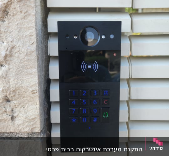 אינטרקום עם מצלמה ומקשים על קיר חיצוני